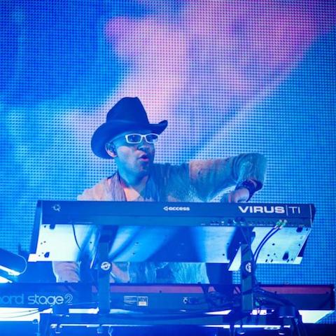 Rodney Alejandro in a cowboy hat on stage playing keys