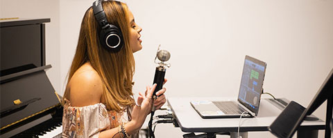 Woman recording vocals in an independent studio environment