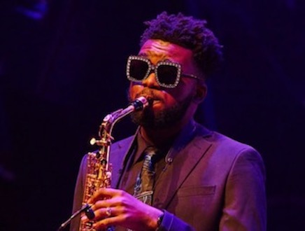 JahQuan Richards wearing sunglasses and playing alto saxophone on stage