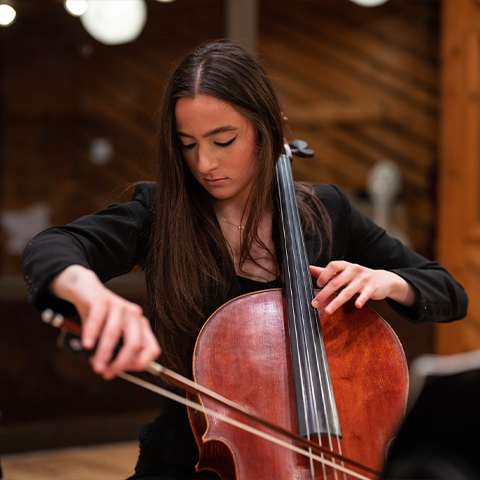 Elaina Spiro headshot - playing the cello looking down