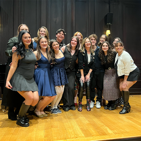 Group photo of Noel Smith and her students posing on stage