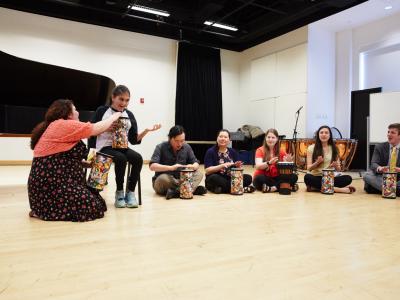 Teacher encouraging students in a drum circle