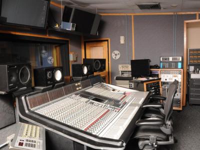 Interior of a mastering studio with large sound mixing board and other equipment
