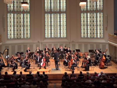 Orchestra performing on stage from the point of view of a balcony seat