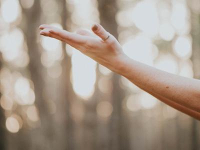 Close up of arm reaching upwards with an open palm.