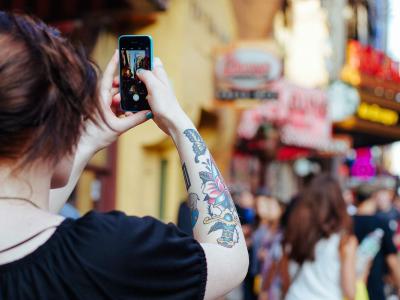 Person with tattoos filming on an iPhone