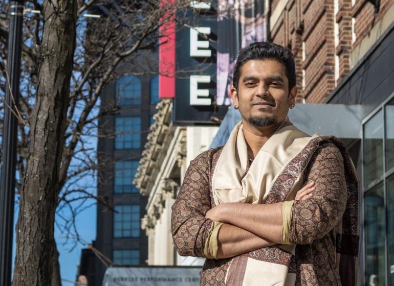 Shivaraj Natraj stands in front of Berklee sign