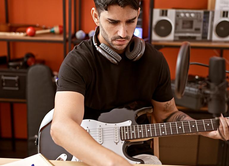 Artist with guitar in music studio