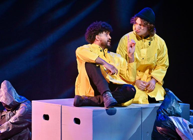 Jared Kellman-Medina (MM '27, opera) and Noah Gunn (MM '26, voice) perform on stage in yellow shirts.