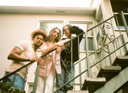 Judah, Maya, and Cinya standing on an outdoor stairway