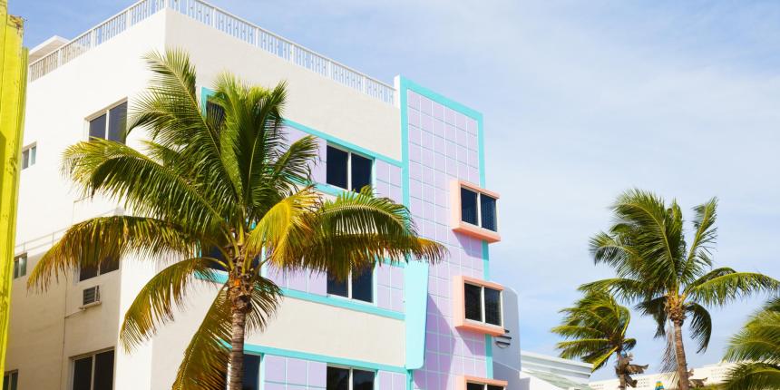 Palm trees in front of a pastel building in Miami