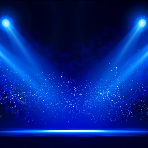 Blue spotlights shing on dimly lit stage
