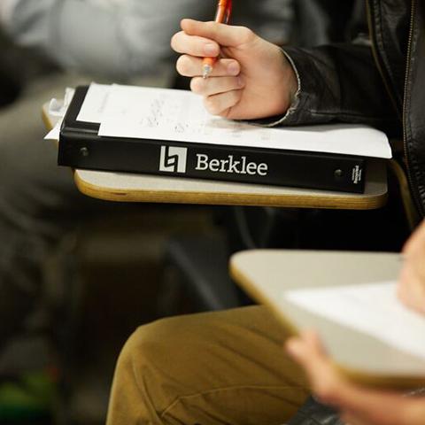 An official Berklee textbook in a classroom setting. Student's pencil is positioned over the book.