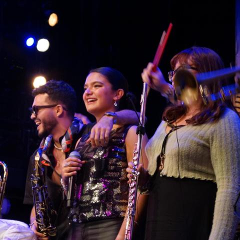 Musicians playing instruments on stage during a live performance.