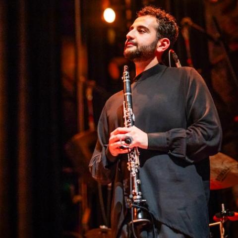 Mehrpouya Daneshvar holding a clarinet on stage