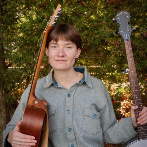 Maren Doughty sitting with two guitars