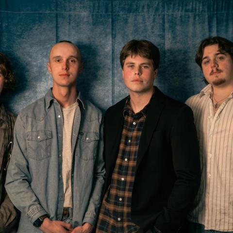 Good Sleepy posing against a moody gray backdrop