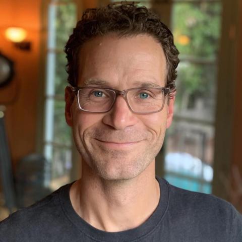 Headshot of Jay Jennings with a window in the background