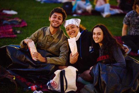 students eating popcorn at the movie on the lawn event