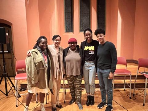 Berklee alums/BSI mentors/Panelists (left to right): Renese King, Abria Smith, Ayeisha Mathis, Mason Bynes, and Moderator, Savannah McLean stand next to eachother smiling in front of the stage