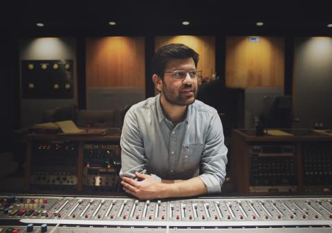 man standing at a studio mixing board
