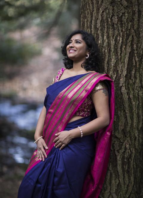 a woman in a sari under a tree