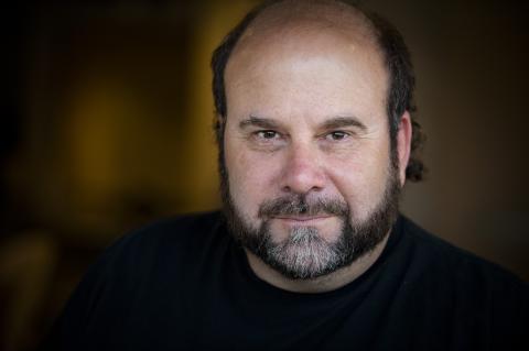Headshot of Scott Martin Gershin against an abstract background 