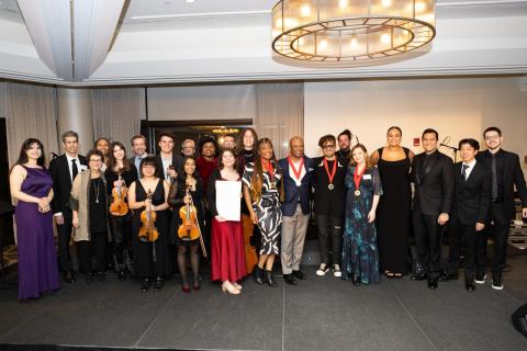 The honorees with award presenters and the ensemble of Berklee students