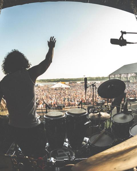 percussionist waving to an outdoor concert audience
