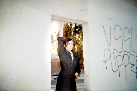 sarah tudzin standing in a white concrete doorway