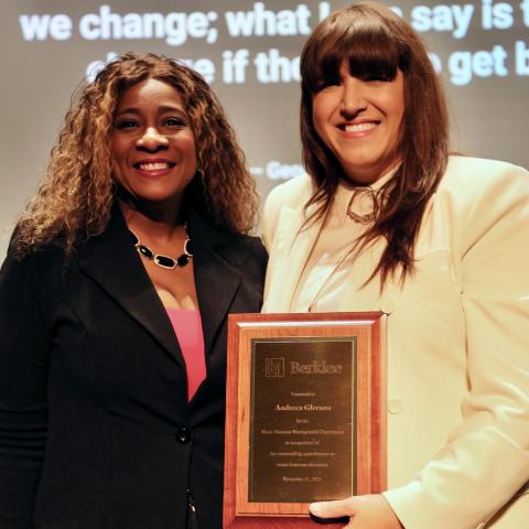 Andreea Gleeson holds a plaque and poses with Tonya Butler on stage