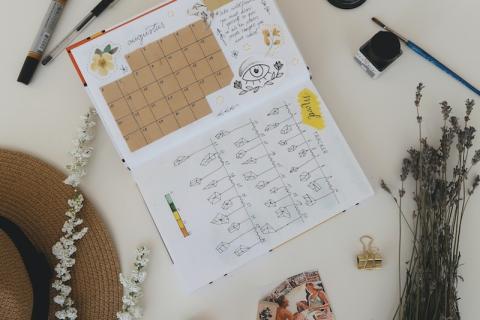 Bullet journal with pens, flowers, and other accessories