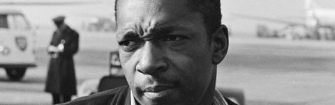 Close-up of John Coltrane standing outside