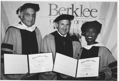 Lee Berk stands with Amar G. Bose and Oleta Adams at the 1994 commencment, all wearing academic regalia.