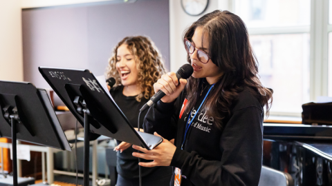 Two students singing in a classroom.