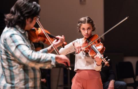 Two string players playing together and facing each other