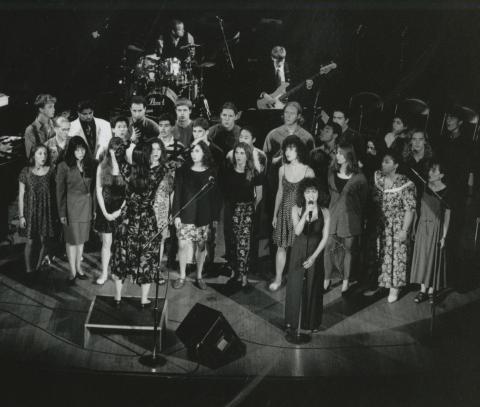 1994 summer choir singing on stage with soloist up front and guitarist and drummer behind