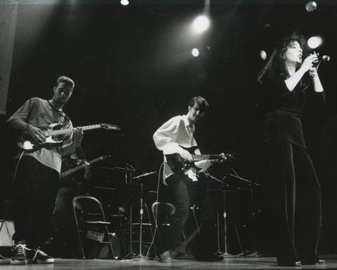 Two students playing guitar and one singing during 1996 5-week program performance