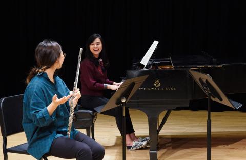 Flute player and pianist rehearsing together.