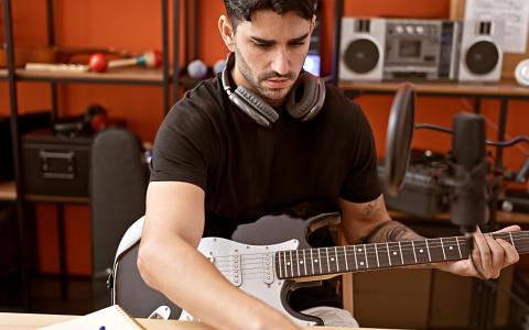 Artist with guitar in music studio