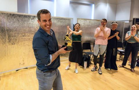 Stephen Spinelli holding a Grammy Award in a Boston Conservatory classroom.