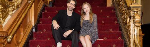 Michael Tacconi and Olivia Goosman sit on the ornate staircase at the Emerson Colonial Theatre