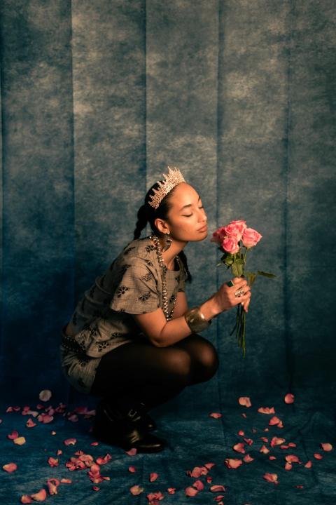 jazz cuti against a stylized backdrop posing with flowers