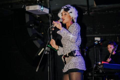 Singer Jazz Cuti singing into a microphone on stage