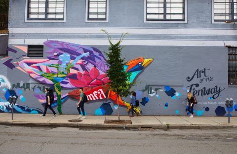 Students walking in front of a mural