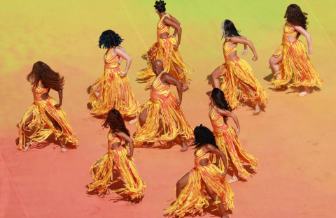 dancers dressed in yellow and orange perform in formation at FIFA world cup halftime show